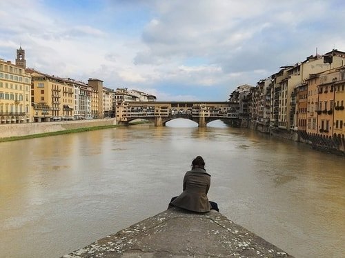 woman looking at old bridge in italy