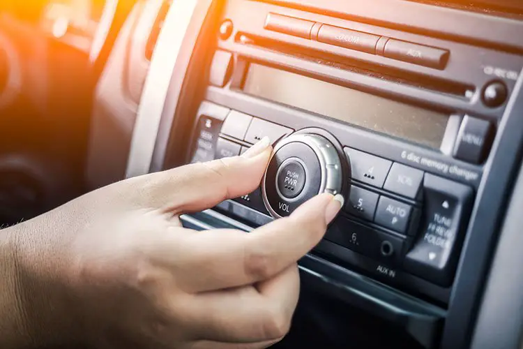 A person turning the volume of music in car