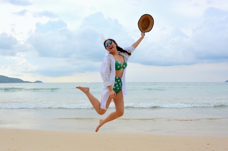 woman on beach wearing long sun protection clothing