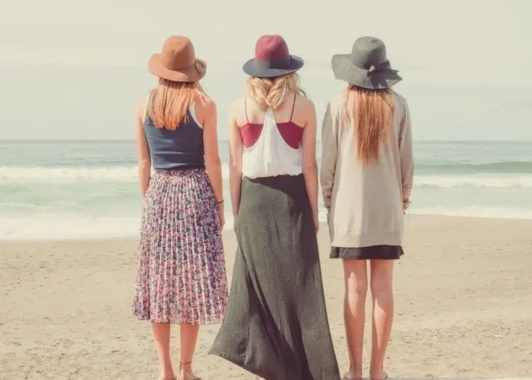 3 women on beach wearing hats